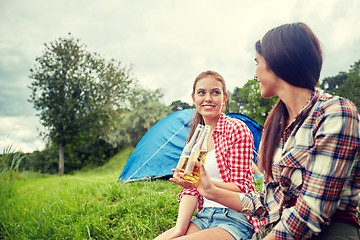 Image showing happy young women with tent and drinks at campsite