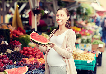 Image showing pregnant woman holding watermelon at street market