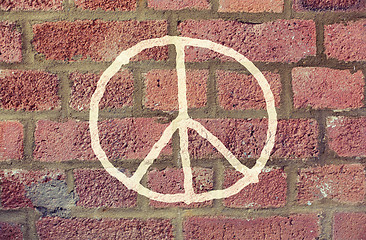 Image showing peace sign drawing on red brick wall