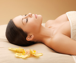 Image showing woman in spa salon lying on the massage desk