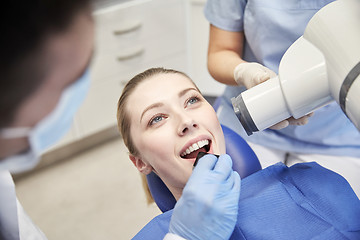 Image showing female patient face with x-ray machine and shield