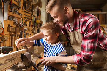 Image showing father and son with rasp working at workshop