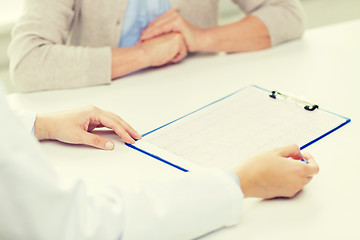 Image showing close up of senior woman and doctor with clipboard