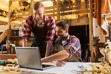 Image showing carpenters with laptop and blueprint at workshop