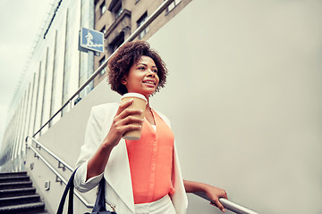 Image showing happy african businesswoman with coffee in city