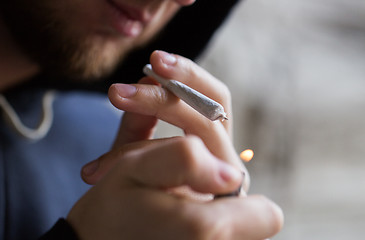 Image showing close up of addict lighting up marijuana joint