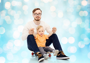 Image showing happy father and little son on skateboard