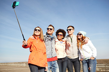 Image showing smiling friends taking selfie with smartphone