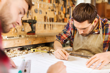 Image showing carpenters with ruler and blueprint at workshop