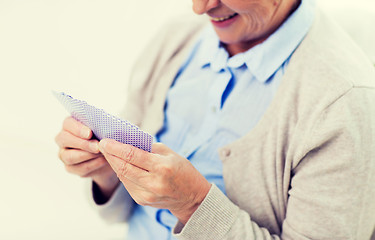 Image showing close up of happy senior woman playing cards