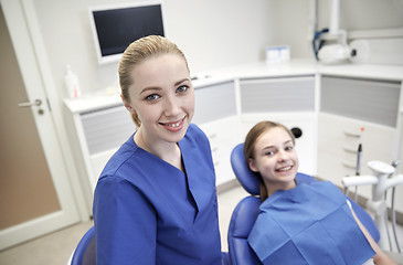 Image showing happy female dentist with patient girl at clinic