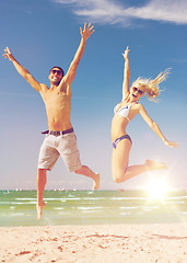 Image showing couple jumping on the beach