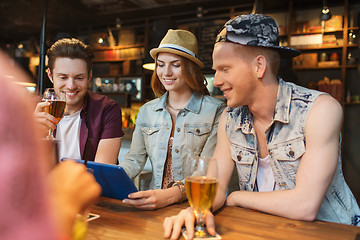 Image showing happy friends with tablet pc and drinks at bar