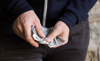 Image showing close up of addict or drug dealer hands with money