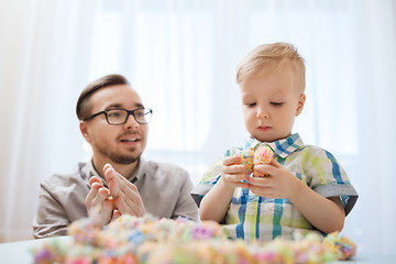 Image showing father and son playing with ball clay at home