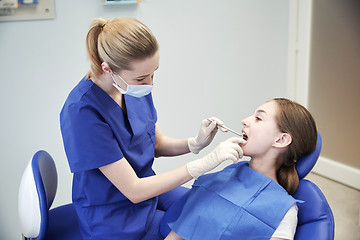 Image showing female dentist checking patient girl teeth