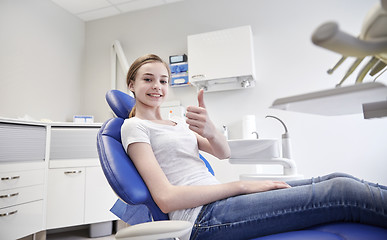 Image showing happy patient girl showing thumbs up at clinic