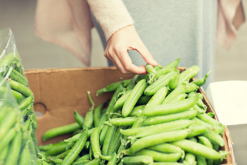 Image showing woman hand choosing green peas at street market