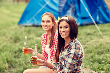 Image showing happy young women with tent and drinks at campsite