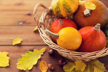 Image showing close up of pumpkins in basket on wooden table