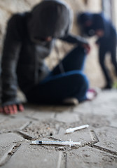 Image showing close up of addicts and drug syringes on ground