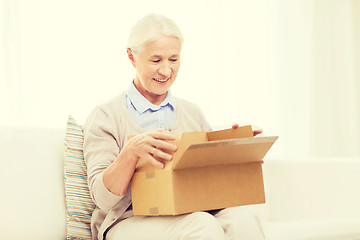 Image showing happy senior woman with parcel box at home