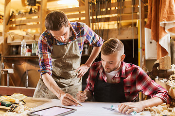 Image showing workmen with tablet pc and blueprint at workshop