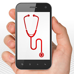 Image showing Health concept: Hand Holding Smartphone with Stethoscope on display