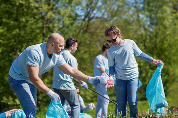 Image showing volunteers with garbage bags cleaning park area