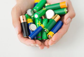 Image showing close up of hands holding alkaline batteries heap