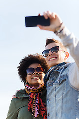 Image showing happy teenage friends in shades taking selfie
