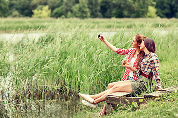 Image showing happy women taking selfie by smartphone outdoors