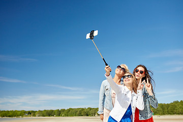 Image showing group of smiling women taking selfie on beach