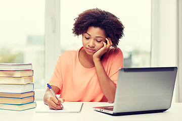 Image showing bored african american woman doing homework home