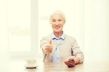 Image showing senior woman with smartphone showing thumbs up