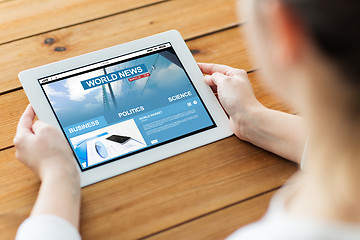 Image showing close up of woman with tablet pc on wooden table