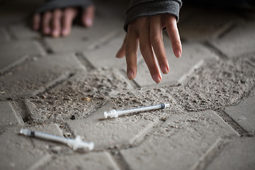 Image showing close up of addict woman hands and drug syringes