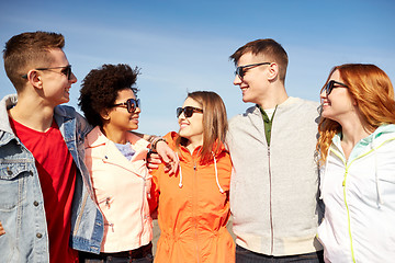 Image showing happy teenage friends in shades talking on street