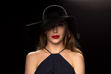 Image showing beautiful woman in black hat over dark background