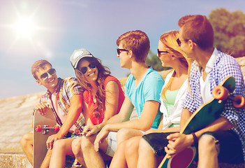 Image showing group of smiling friends sitting on city street