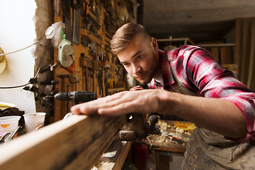 Image showing carpenter working with wood plank at workshop