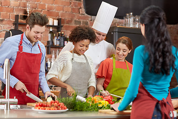 Image showing happy friends and chef cook cooking in kitchen