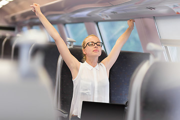 Image showing Woman streching while travelling by train.