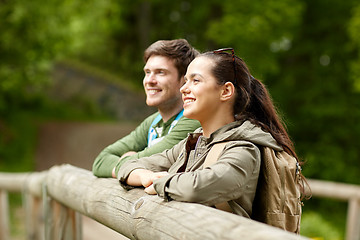 Image showing smiling couple with backpacks on bridge in nature