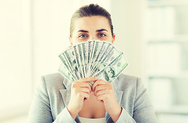 Image showing woman hiding her face behind us dollar money fan