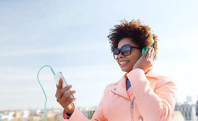 Image showing happy young woman with smartphone and headphones