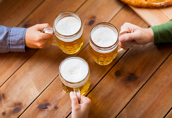 Image showing close up of hands with beer mugs at bar or pub