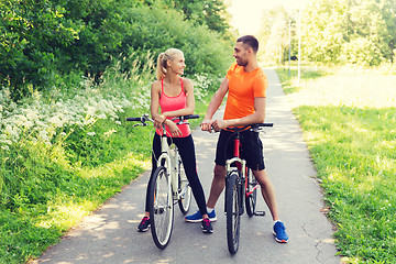 Image showing happy couple riding bicycle outdoors