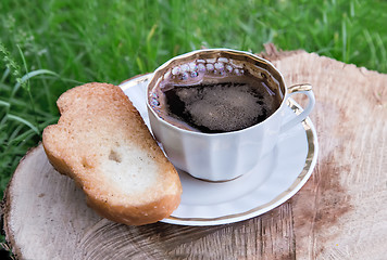Image showing Still life: a Cup of black coffee in the garden.