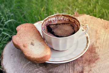 Image showing Still life: a Cup of black coffee in the garden.